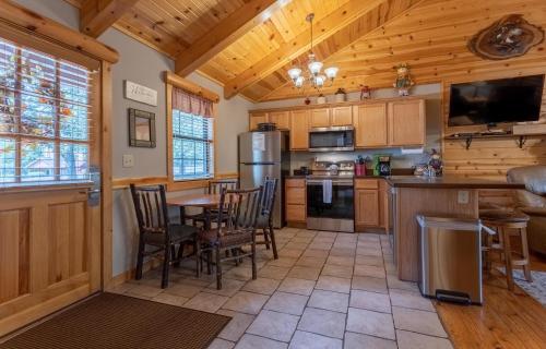 a kitchen with wooden cabinets and a table and chairs at Ozarks Oasis cabin in Branson