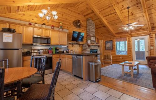 a kitchen and dining room of a log cabin at Ozarks Oasis cabin in Branson