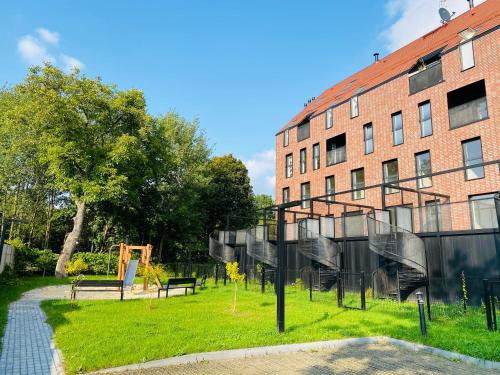 un parque frente a un edificio de ladrillo en Apartament Nowy Verdon Ruda Śląska en Ruda Śląska