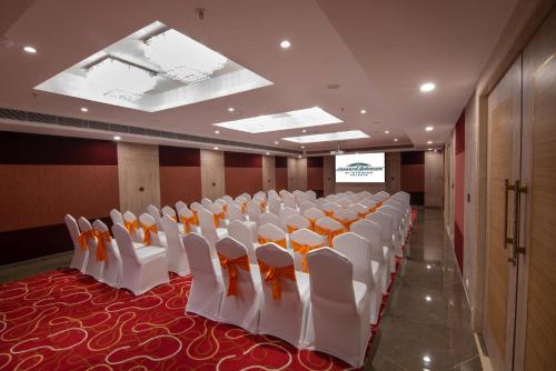 a conference room with rows of white chairs in it at Howard Johnson by Wyndham, Kolkata Airport in Kolkata