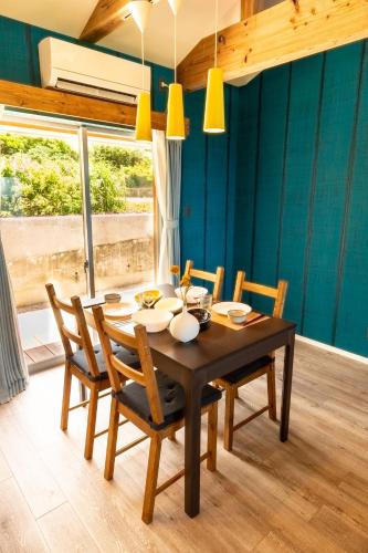 a dining room with a wooden table and chairs at UmiToSora Ishigakijima in Ishigaki Island