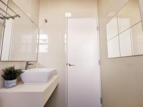 a white bathroom with a sink and a shower at Skypod Residence Puchong in Puchong