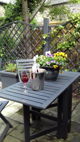 a picnic table with a glass of wine and flowers at No11 Boutique Hotel & Brasserie in Edinburgh