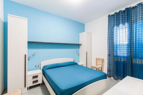 サン・ヴィート・ロ・カーポにあるB&B "Perla del Sud"のベッドルーム1室(ブルーヘッドボード付きのベッド1台付)