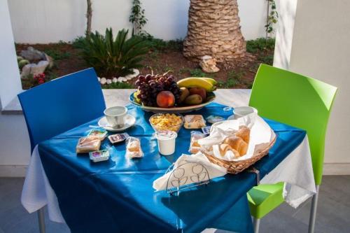 een blauwe tafel met een bord eten en een fruitschaal bij B&B "Perla del Sud" in San Vito lo Capo