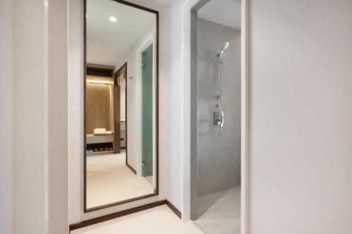 a bathroom with a mirror and a shower at VALA Hua Hin - Nu Chapter Hotels in Cha Am