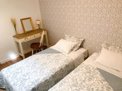 um quarto com 2 camas e uma secretária com um espelho. em L'AtelieR Guest House Yonago em Yonago