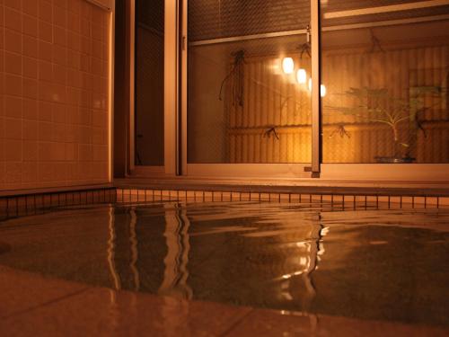 une piscine vide devant une fenêtre dans l'établissement Echigoya Ryokan, à Ogano