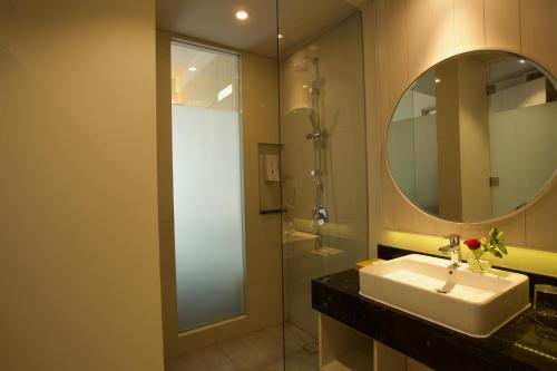 a bathroom with a sink and a mirror and a shower at Swiss-Belinn Cikarang in Cikarang