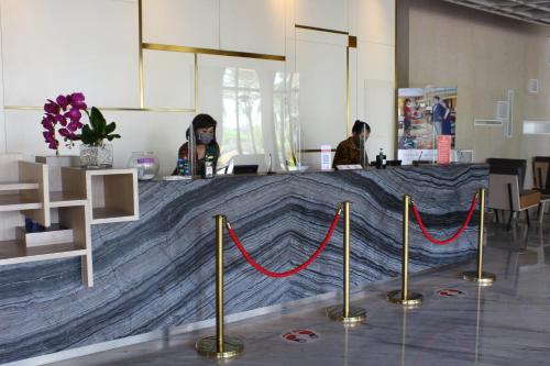 a counter with red ropes in a room with people at Swiss-Belinn Cikarang in Cikarang