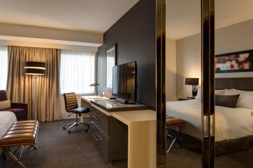 a hotel room with a bed, chair, desk and a television at Godfrey Hotel Chicago in Chicago