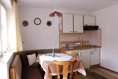 a living room with a table and a kitchen at Pension Leitner in Hofen