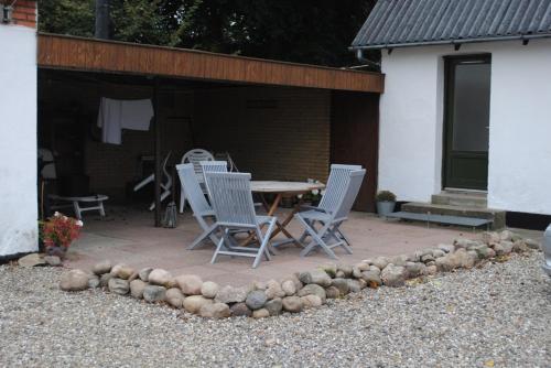 a patio with a table and chairs in front of a building at BrusaaUdlejning in Nibe