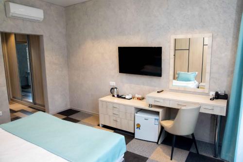 a bedroom with a desk and a mirror and a bed at Гостиничный комплекс Be Fine in Besqaynar