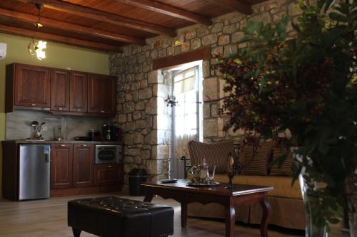 a living room with a table and a kitchen at Εn Plo Luxury Suites in Karavostasion