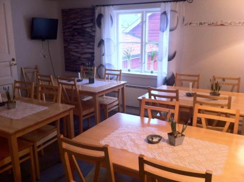 un restaurante con mesas y sillas de madera y una ventana en STF Hostel Mariestad, en Mariestad