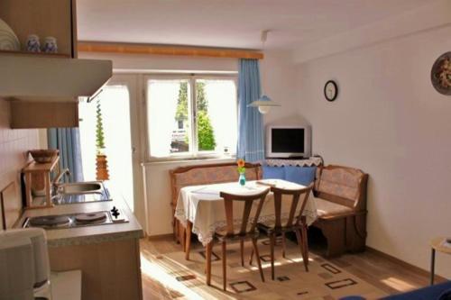 a kitchen and dining room with a table and chairs at Pension Leitner in Hofen