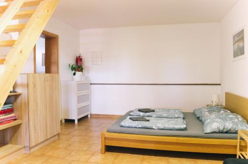 een slaapkamer met een bed en een trap bij Ubytování Na Sklípku in Jevišovka