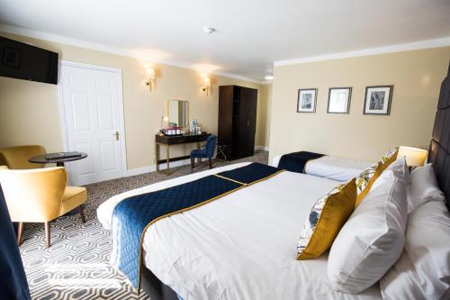 a hotel room with two beds and a desk at Rossett Hall Hotel in Rossett