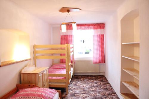 a small room with a bunk bed and a window at Chalupa u Smolíků in Brtnice