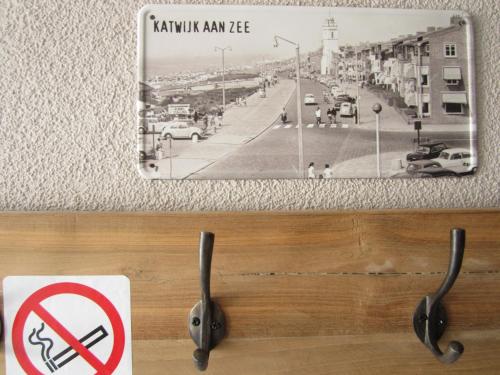 huisje de Strandjutter في Katwijk aan Zee: وضع علامة على الحائط مع وجود علامة بعدم التدخين