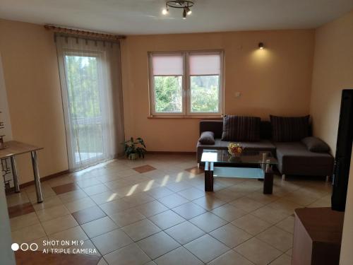 a living room with a couch and a coffee table at Domek u Lucy in Rabka