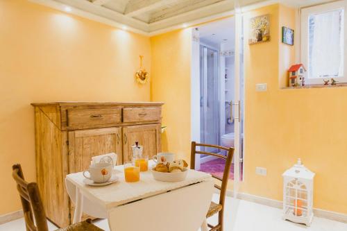 een eetkamer met een tafel en stoelen en oranje muren bij La Casa degli Uccellini in Lucca