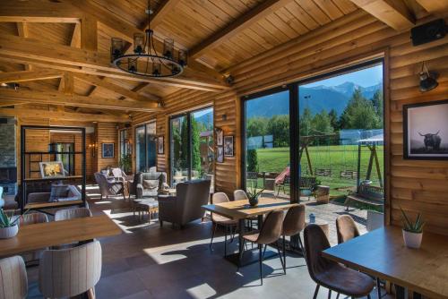 a living room with tables and chairs and large windows at Cornelia Deluxe Residence in Bansko