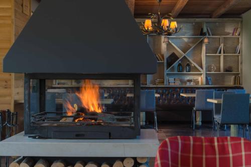 a fireplace in a room with chairs and a table at Cornelia Deluxe Residence in Bansko