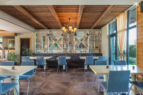 a restaurant with tables and chairs and a couch at Cornelia Deluxe Residence in Bansko