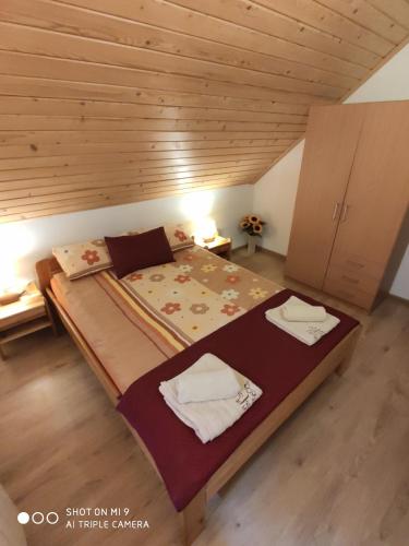 a large bed in a room with a wooden ceiling at Domek u Lucy in Rabka-Zdrój