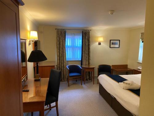 a hotel room with a bed and a desk at Rossett Hall Hotel in Rossett