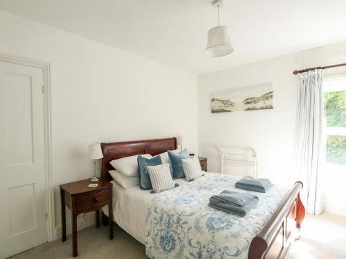 a bedroom with a bed with blue pillows on it at Elm Villa in Wareham