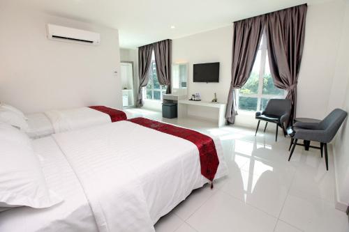 a white bedroom with a large bed and a chair at B&L HOTEl in Sungkai