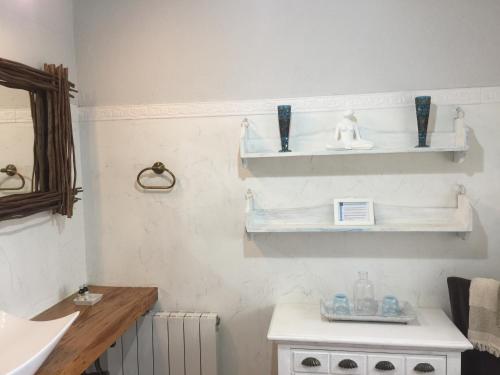 uma casa de banho com prateleiras brancas na parede em Agroturismo Ibarra em Amorebieta-Echano