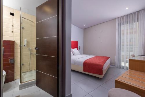 a bedroom with a bed and a bathroom with a shower at Habitat Hotel in Kilkís
