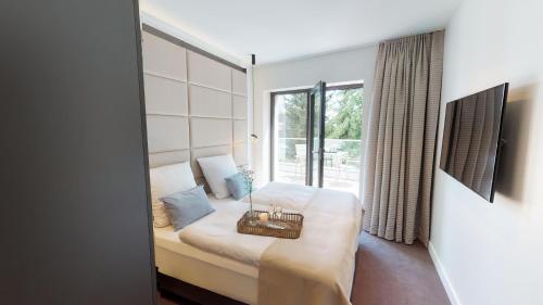 - une chambre avec un lit et une grande fenêtre dans l'établissement White Pearl Apartment 3.04, à Timmendorfer Strand