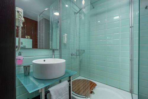 a bathroom with a sink and a shower with blue tiles at Habitat Hotel in Kilkís
