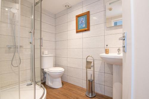 a bathroom with a shower and a toilet and a sink at Millstone Country Inn in Hathersage