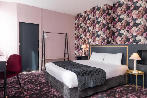 um quarto de hotel com uma cama e uma parede floral em The Originals Boutique, Hôtel Victoria, Châtelaillon-Plage em Châtelaillon-Plage