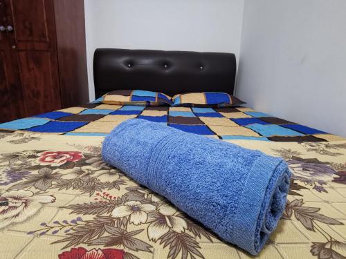 a blue blanket laying on top of a bed at AniS Homestay Nilai USIM KLIA INTI Manipal Nilai 3 in Nilai