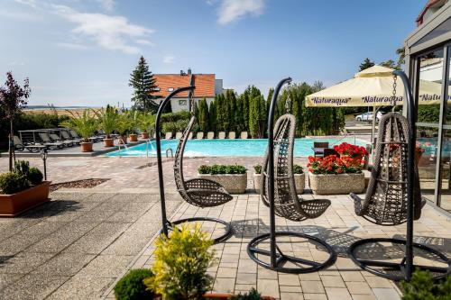 a group of chairs in front of a swimming pool at Vinosseum Bor- és Apartmanház in Sopron