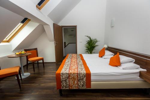 a bedroom with a bed and a table and chairs at Vinosseum Bor- és Apartmanház in Sopron