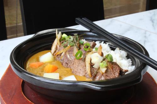 a bowl of food with meat and vegetables and rice at Swiss-Belinn Cikarang in Cikarang