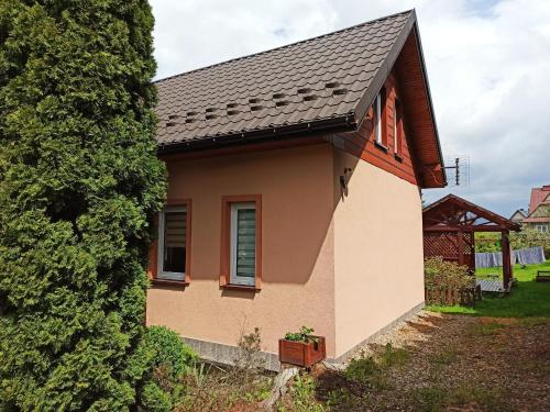 a small house with a black roof at Domek u Lucy in Rabka