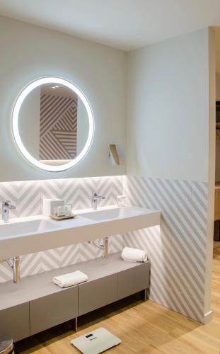 a bathroom with a sink and a mirror at Suites Plaza Hotel & Wellness in Andorra la Vella