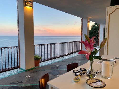 a balcony with a table and a view of the ocean at Villa Le Baste in Furore