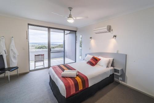 a bedroom with a large bed and a large window at Cosy Corner Sea View Apartments in Albany