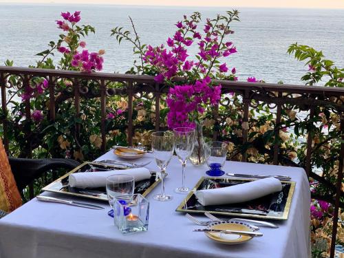 a table with a white table cloth and wine glasses at Villa Le Baste in Furore