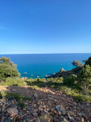 a rocky hillside with the ocean in the background at Abba Urci in Tertenìa